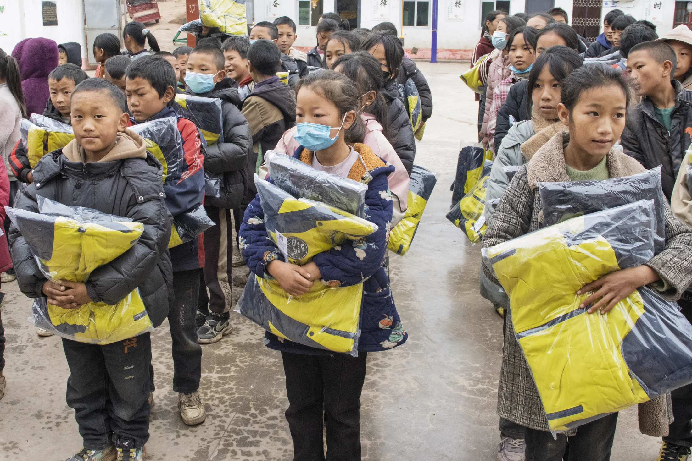 Students holding new winter clothing