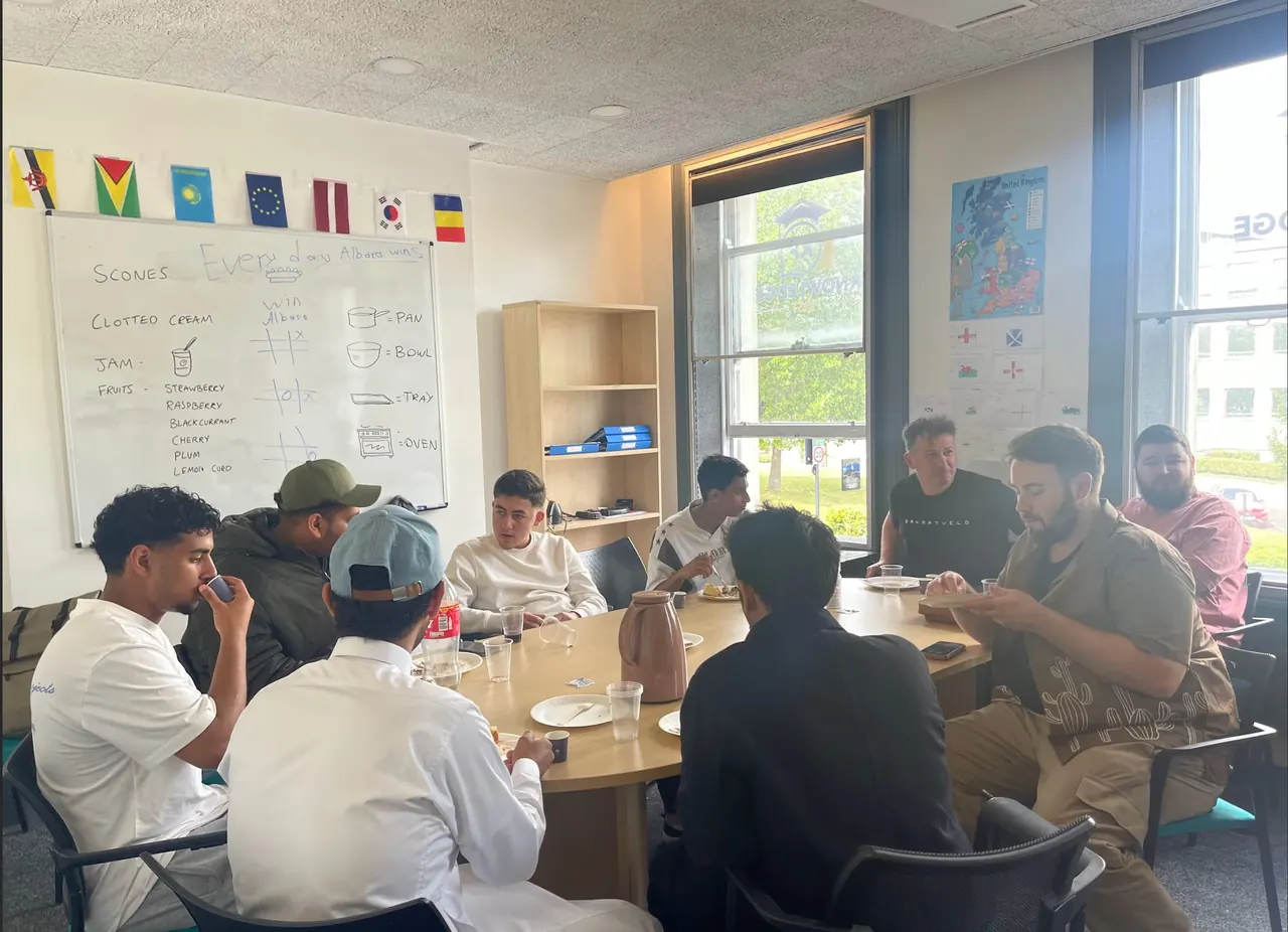 Knowledge First — A teacher and students gathered around a classroom table